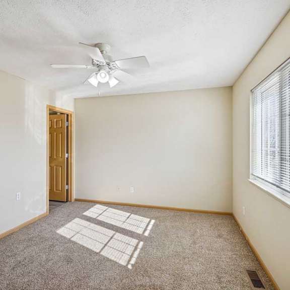 Thumbnail 42 of 54 A room with a ceiling fan and a window with blinds.
