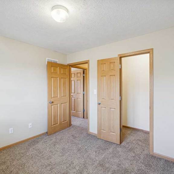 Thumbnail 45 of 54 A room with two doors and a carpeted floor.