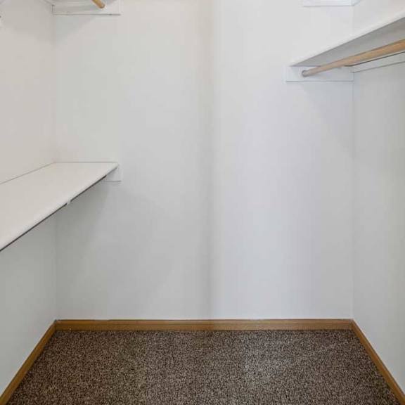 Thumbnail 34 of 54 A white wall with a brown carpet and a white shelf.