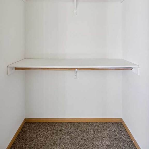 Thumbnail 54 of 54 A white wall with a shelf and a hanging rod.