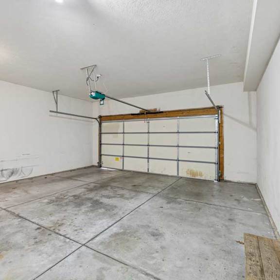 Thumbnail 39 of 54 A garage with a white wall and a wooden door.