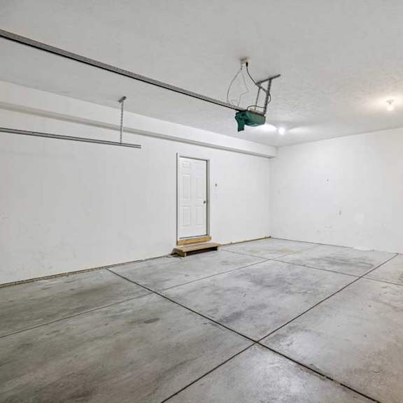Thumbnail 44 of 54 A basketball hoop is mounted on a wall in a large, empty room with concrete flooring.