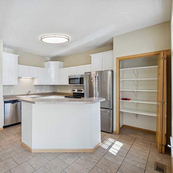 Thumbnail 52 of 54 A kitchen with white cabinets and a refrigerator.