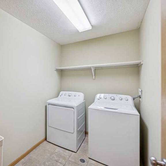 Thumbnail 53 of 54 A small laundry room with a washer and dryer.