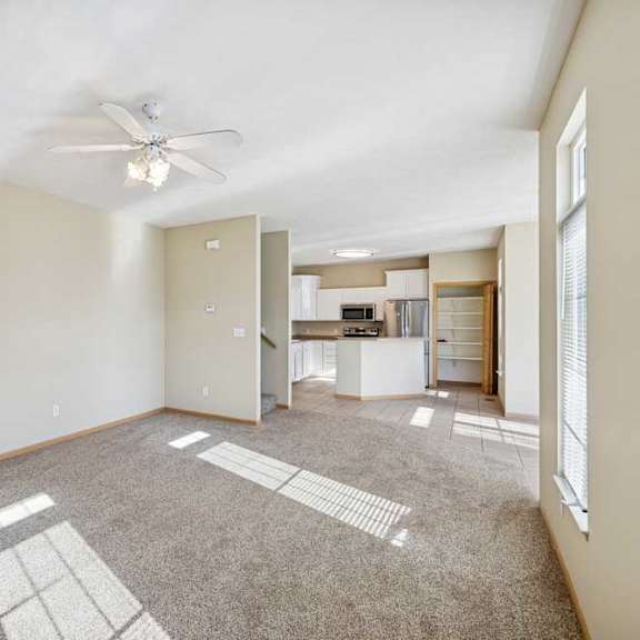 Thumbnail 38 of 54 A spacious room with a ceiling fan and carpeted floor.