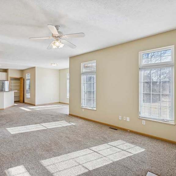 Thumbnail 37 of 54 A spacious room with a carpeted floor and a ceiling fan.