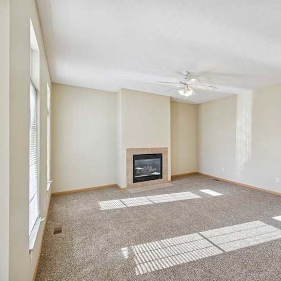 Thumbnail 49 of 54 A living room with a fireplace and a carpeted floor.