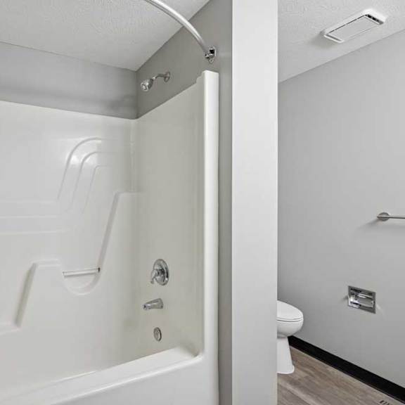 Thumbnail 34 of 79 A white bathroom with a walk in shower and toilet.
