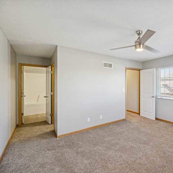Thumbnail 26 of 79 A room with a ceiling fan and two windows.