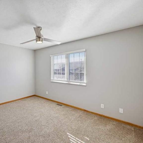Thumbnail 25 of 79 A room with a ceiling fan and a window with blinds.