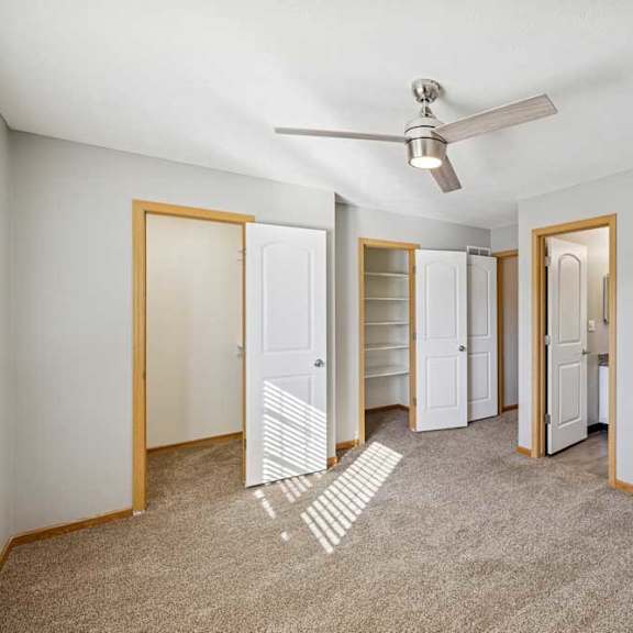 Thumbnail 15 of 79 A room with a ceiling fan and three white doors.