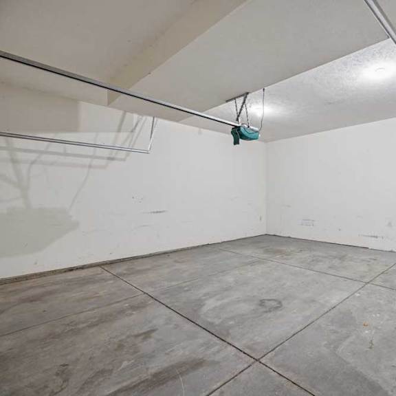 Thumbnail 32 of 79 A room with a white wall and grey floor tiles.
