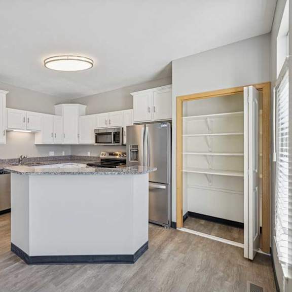 Thumbnail 23 of 79 A kitchen with white cabinets and a central island.