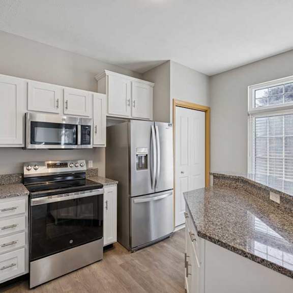 Thumbnail 18 of 79 A kitchen with granite countertops and stainless steel appliances.