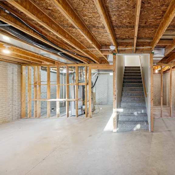 Thumbnail 67 of 79 A spacious interior of a building under construction with exposed wooden beams and unfinished walls.