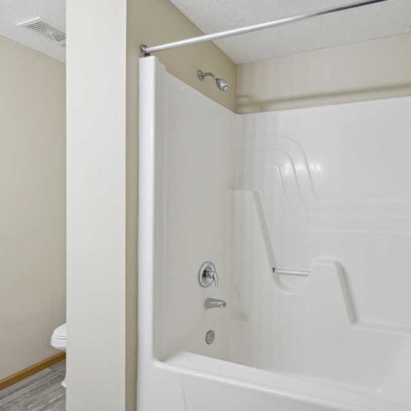 Thumbnail 77 of 79 A white bathtub with a shower head and faucet.