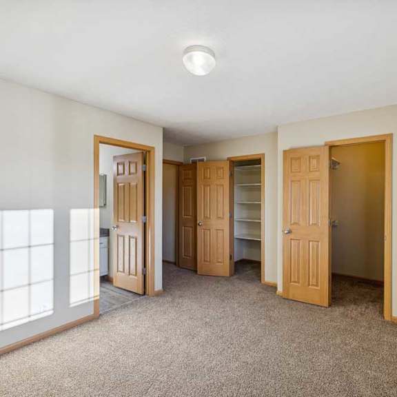 Thumbnail 73 of 79 A room with carpeted floor and four doors.