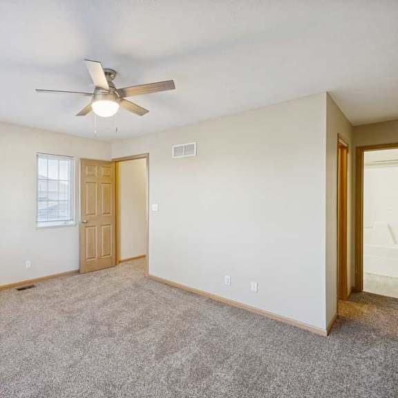 Thumbnail 79 of 79 A room with a ceiling fan and carpeted floor.