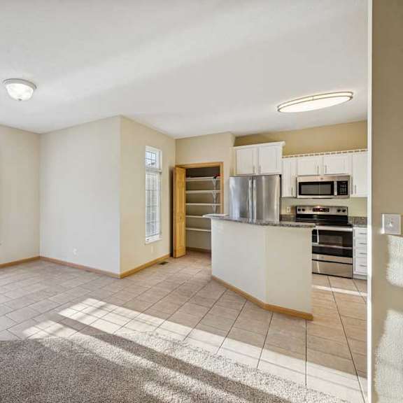 Thumbnail 75 of 79 A spacious living room with a kitchen area in the background.