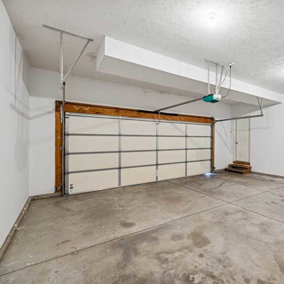 Thumbnail 69 of 79 A garage with a white wall and a wooden door.