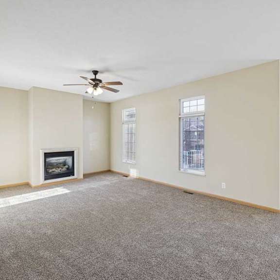 Thumbnail 56 of 79 A living room with a fireplace and a ceiling fan.