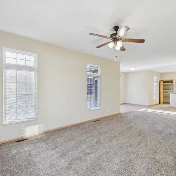 Thumbnail 64 of 79 A spacious room with a ceiling fan and carpeted floor.
