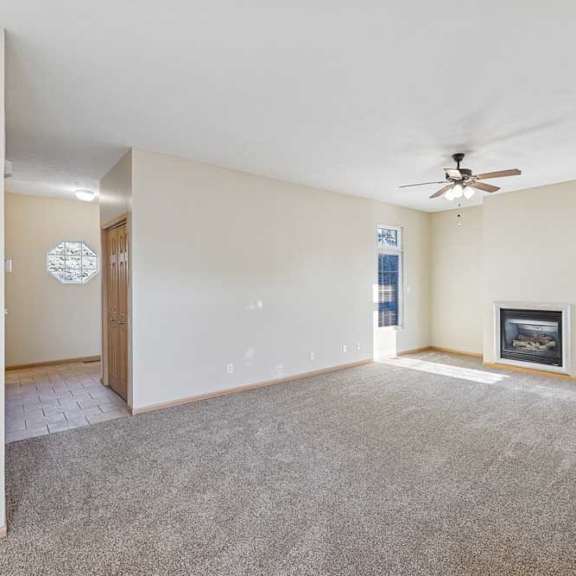 Thumbnail 65 of 79 A spacious living room with a fireplace and a ceiling fan.