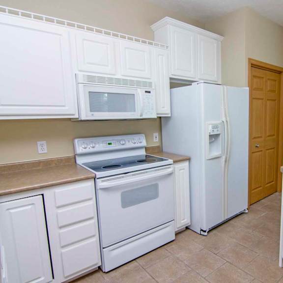 Thumbnail 3 of 13 a kitchen with white appliances and white cabinets