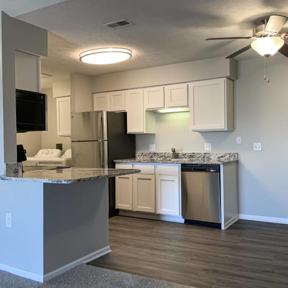 Thumbnail 3 of 22 Renovated kitchen with white cabinets and stainless steel appliances at Eagle Run Apartments in Omaha Nebraska
