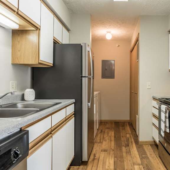 Thumbnail 14 of 22 A kitchen with stainless steel appliances and white and oak cabinets.