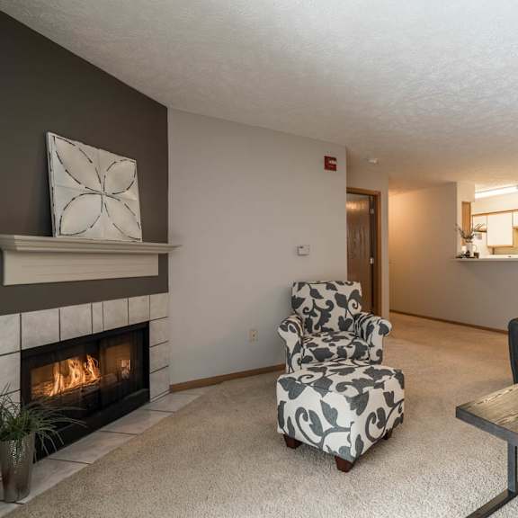 Thumbnail 3 of 13 A living room with a fireplace and a couch.