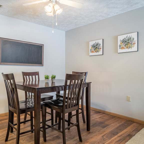 Thumbnail 5 of 13 A dining room with a wooden table and chairs.