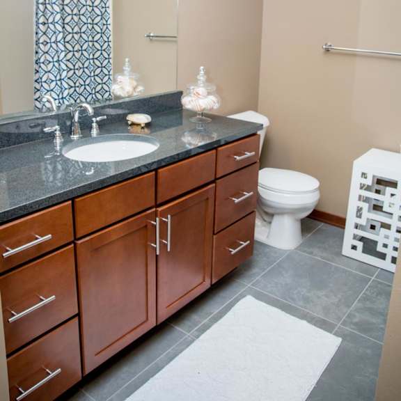 Thumbnail 14 of 14 A bathroom with a sink, toilet, and a mirror.