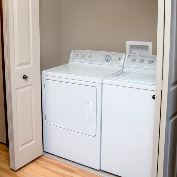 Thumbnail 15 of 15 A white washer and dryer in a small laundry closet