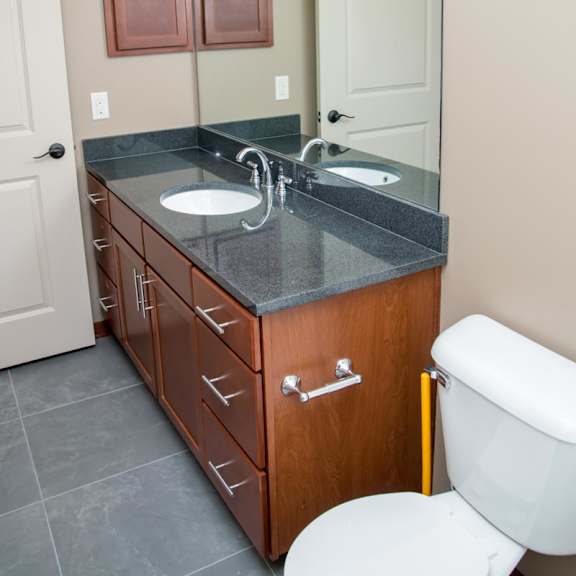 Thumbnail 14 of 15 A bathroom with a sink, mirror, and toilet.