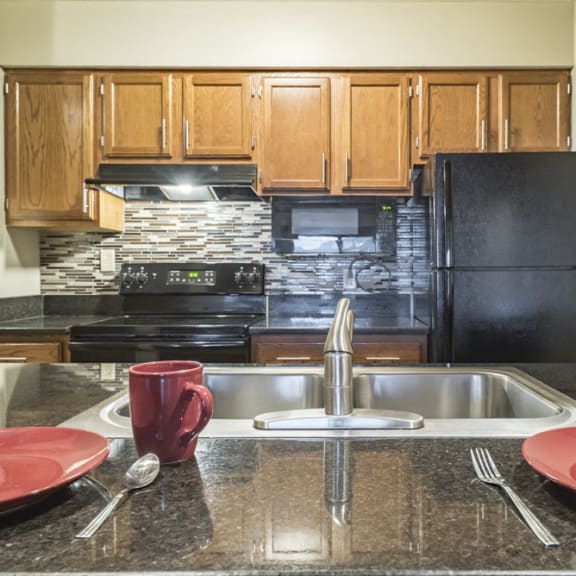 Thumbnail 3 of 15 renovated kitchen with granite counters and new black appliances