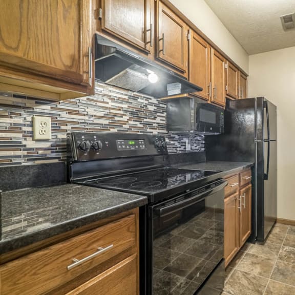Thumbnail 2 of 15 a galley style kitchen with new cabinets, granite countertops and tile backsplash