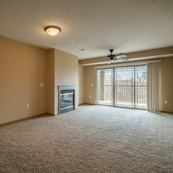 Thumbnail 2 of 12 a living room with a fireplace and a ceiling fan