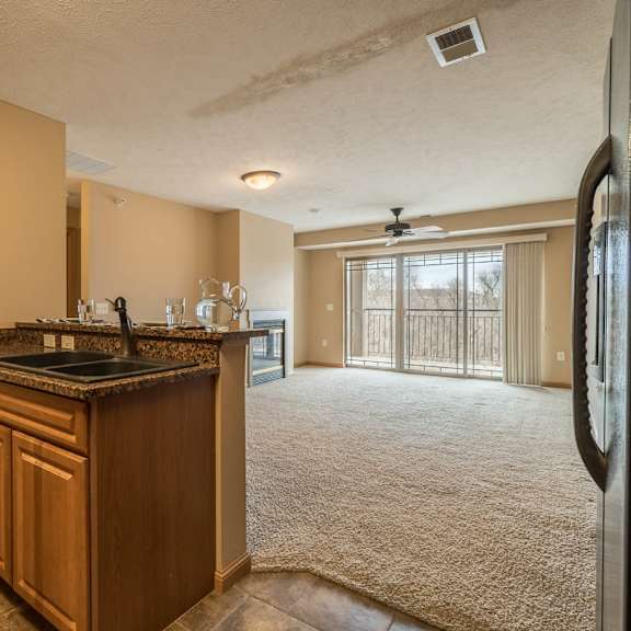 Thumbnail 5 of 12 a kitchen looking into carpeted living room
