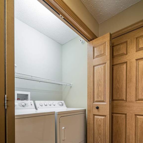 Thumbnail 11 of 12 a washer and dryer in a laundry room with a door