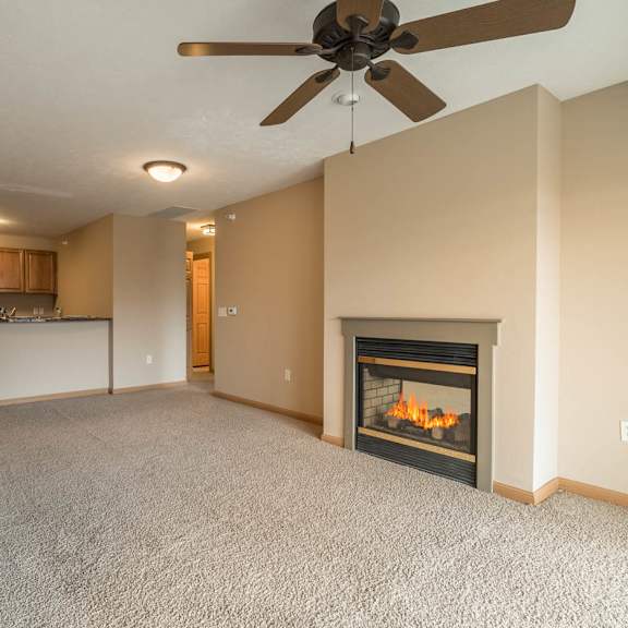 Thumbnail 3 of 12 a living room with a fireplace  and a kitchen