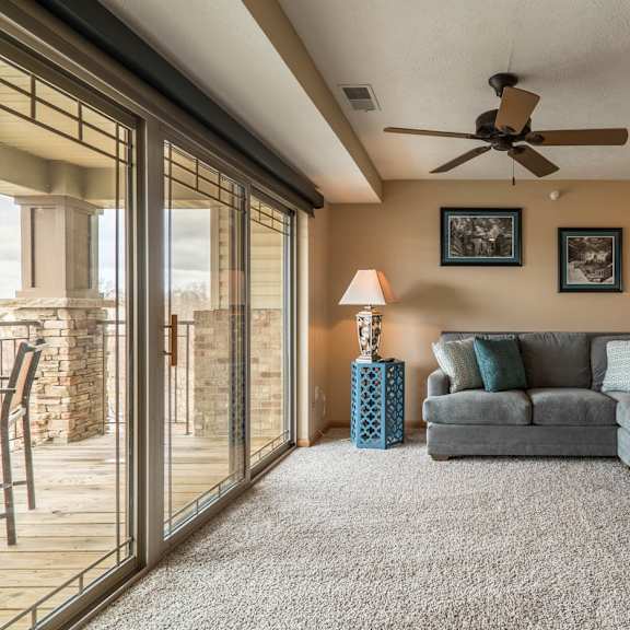Thumbnail 7 of 17 a living room with a couch and a ceiling fan