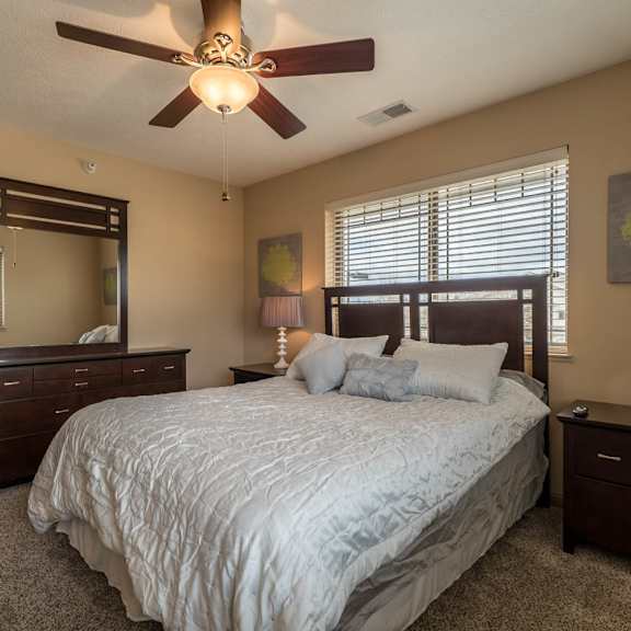 Thumbnail 16 of 17 a bedroom with a large bed and a ceiling fan