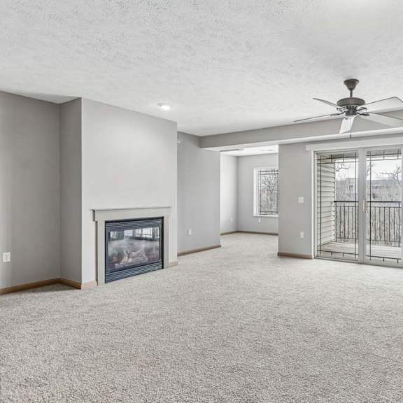 Thumbnail 16 of 31 Open apartment living area featuring a fireplace and balcony access.
