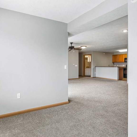 Thumbnail 17 of 31 Open living area with carpeted floors and view into kitchen.