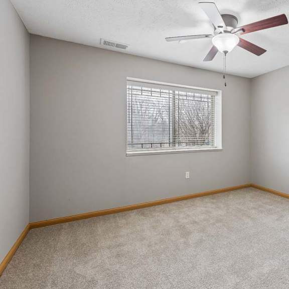 Thumbnail 12 of 19 Unfurnished bedroom featuring neutral carpet, ceiling fan, and single window.