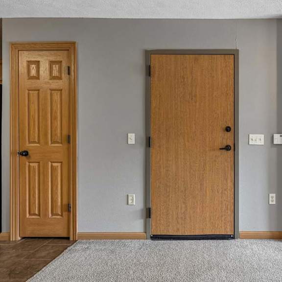 Thumbnail 7 of 19 Living room view featuring entry door, fireplace, and neutral carpet.