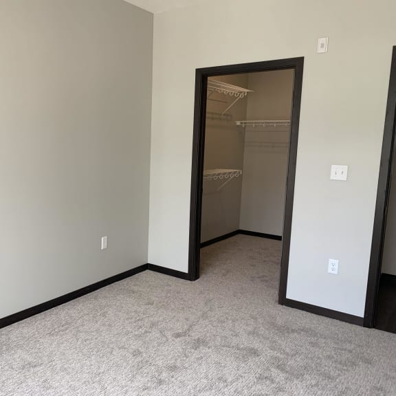 Thumbnail 12 of 18 bedroom features spacious walk-in closet with shelving at Haven at Uptown