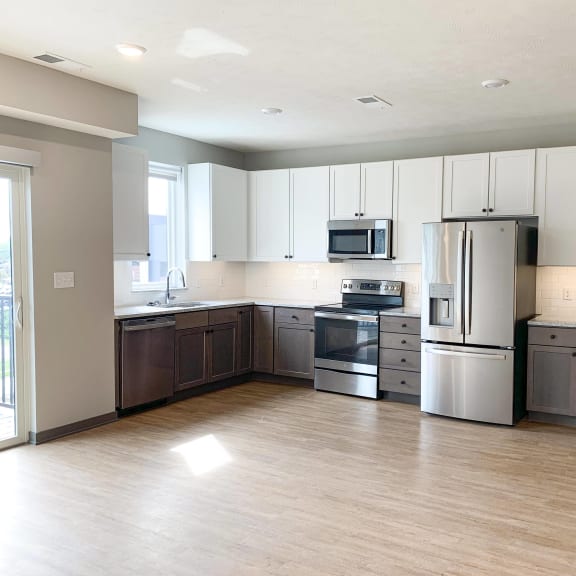 Thumbnail 4 of 17 Spacious open kitchen with matching steel appliances and under cabinet lighting