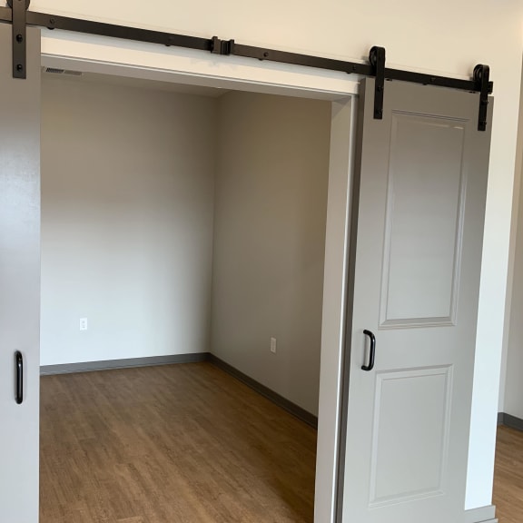 Thumbnail 7 of 17 Sliding gray barn doors to the spacious office area or den